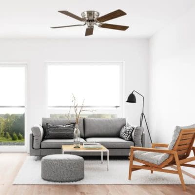 Salon avec canapé gris, fauteuil en bois, ventilateur plafond vintage chromé et bois (modèle Classic Flat de Casafan)