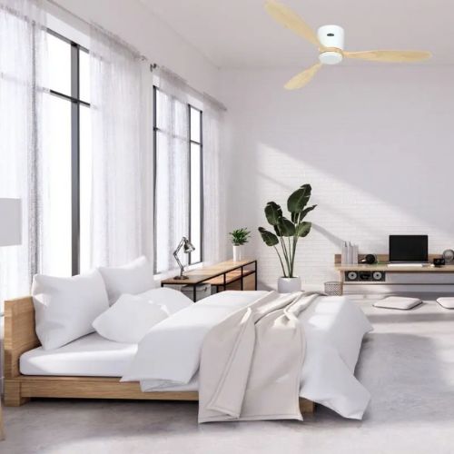 Chambre lumineuse et épurée avec lit en bois, draps blancs et ventilateur de plafond au-dessus, ambiance calme pour dormir avec un ventilateur allumé la nuit
